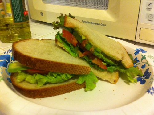 Avocado, lettuce and tomato on sourdough, sliced in half.